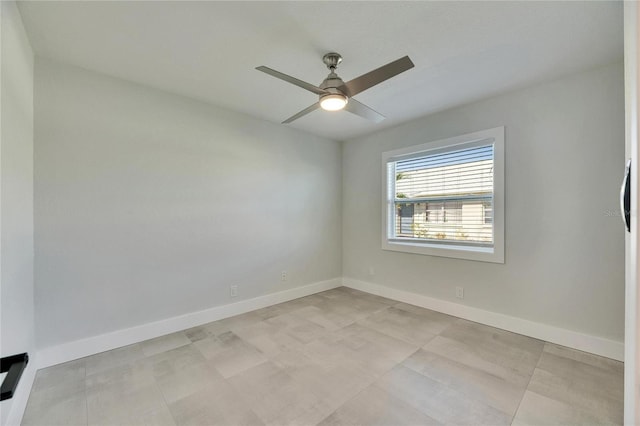 spare room with ceiling fan and baseboards