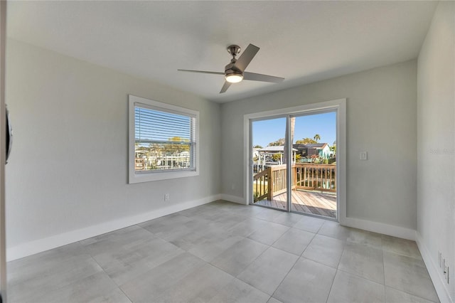 unfurnished room with a ceiling fan and baseboards