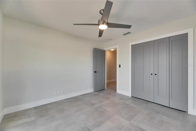 unfurnished bedroom featuring baseboards, visible vents, ceiling fan, and a closet