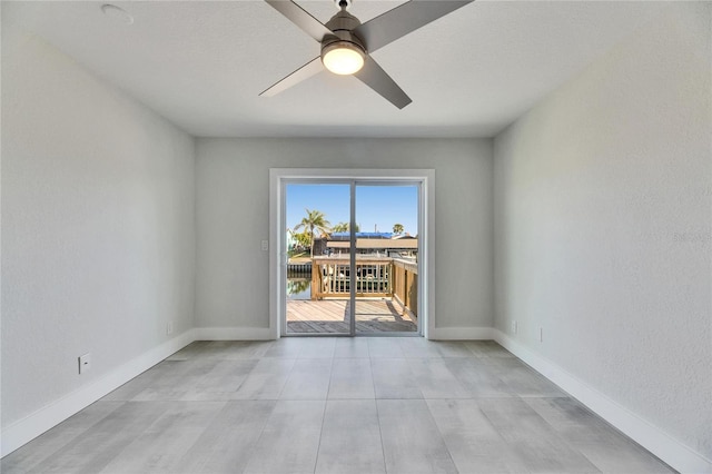 empty room featuring ceiling fan and baseboards