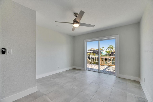 spare room featuring baseboards and a ceiling fan