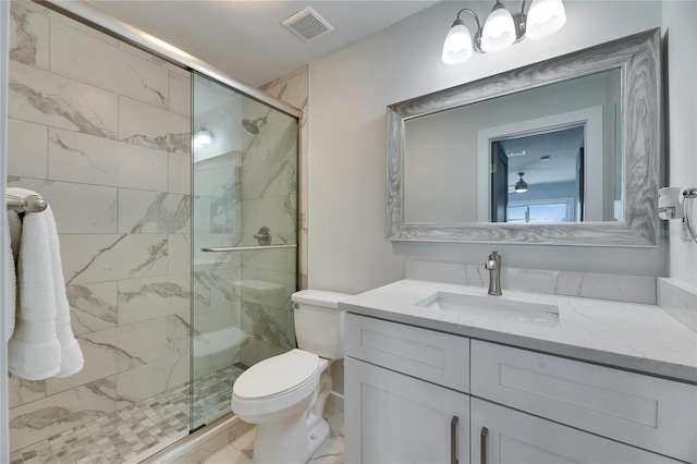 bathroom featuring toilet, vanity, visible vents, marble finish floor, and a shower stall