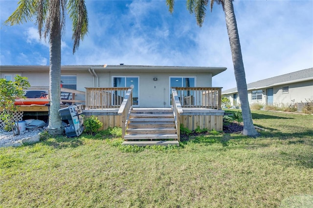 view of front of house featuring stairs, a front yard, a wooden deck, and stucco siding