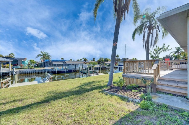 view of yard with a water view and a dock