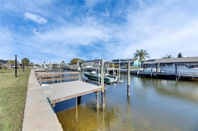 dock area with a yard, a water view, and boat lift