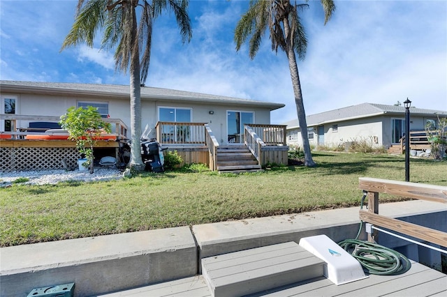 view of front of house with a front lawn, a wooden deck, and stucco siding