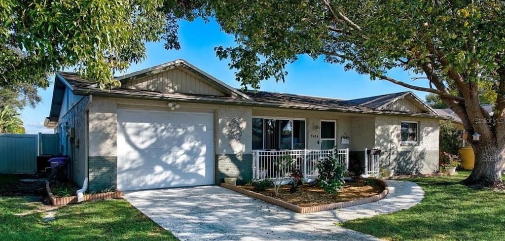 single story home with brick siding, a porch, an attached garage, driveway, and a front lawn