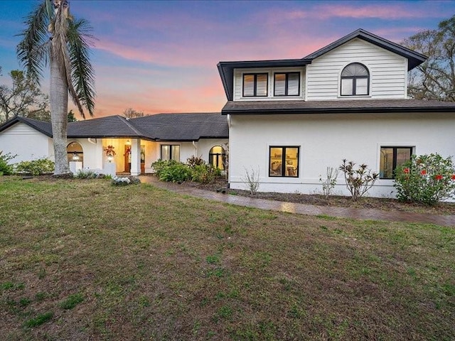 view of front of house featuring a front lawn and stucco siding