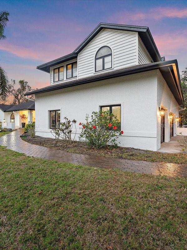 view of side of property with a yard, an attached garage, and stucco siding