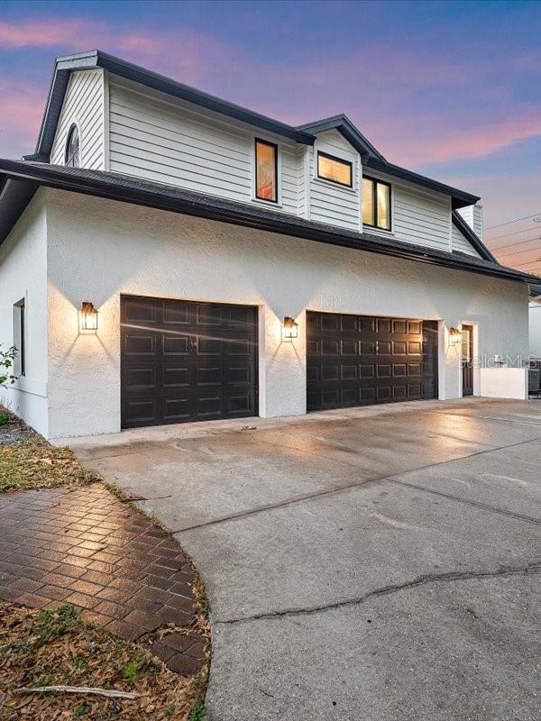 view of front of property with a garage, driveway, and stucco siding