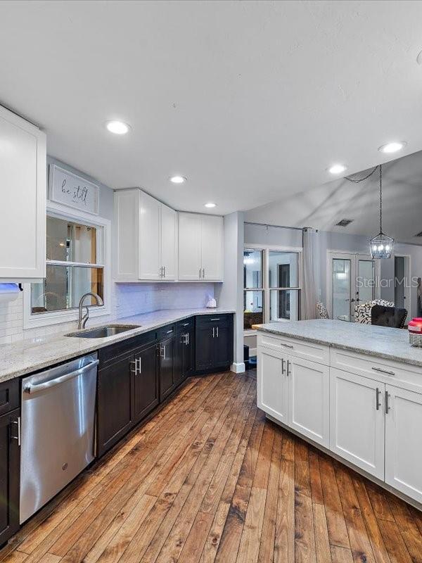 kitchen with backsplash, light wood-style floors, white cabinetry, a sink, and dishwasher