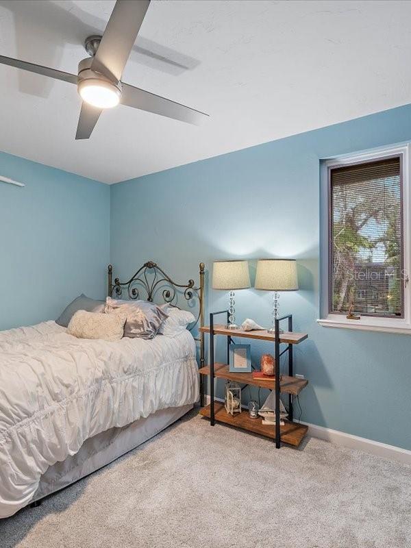 carpeted bedroom featuring ceiling fan and baseboards