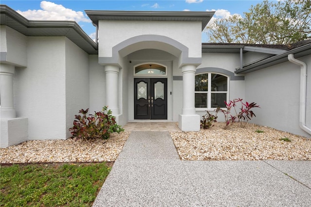 doorway to property featuring french doors and stucco siding