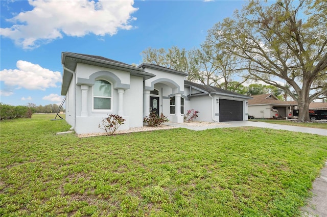 view of front facade with an attached garage, stucco siding, concrete driveway, and a front yard