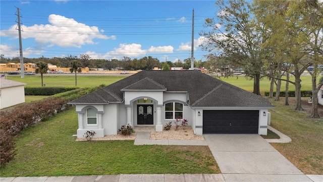 single story home featuring stucco siding, a shingled roof, an attached garage, driveway, and a front lawn