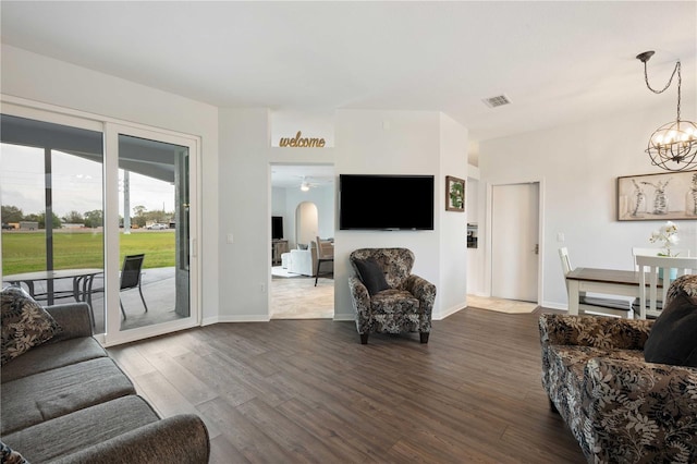 living room featuring dark wood-style floors, baseboards, visible vents, and a notable chandelier