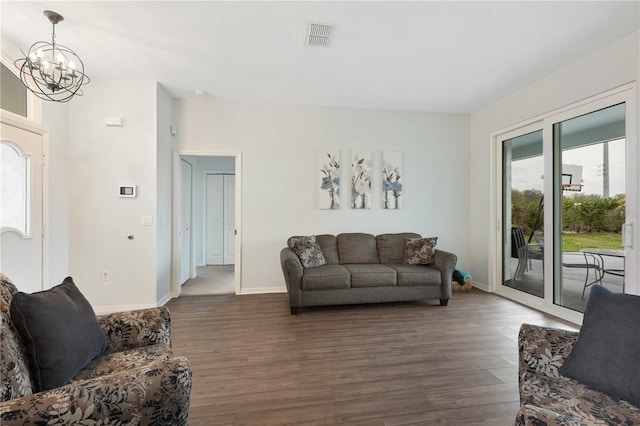 living room with an inviting chandelier, baseboards, visible vents, and dark wood-style flooring