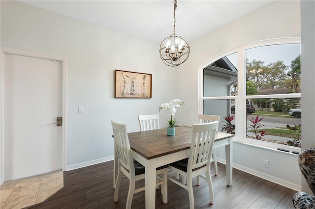 dining space with a chandelier, baseboards, and wood finished floors