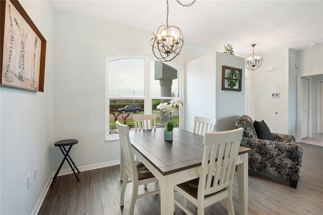 dining area featuring a chandelier, light wood-type flooring, and baseboards