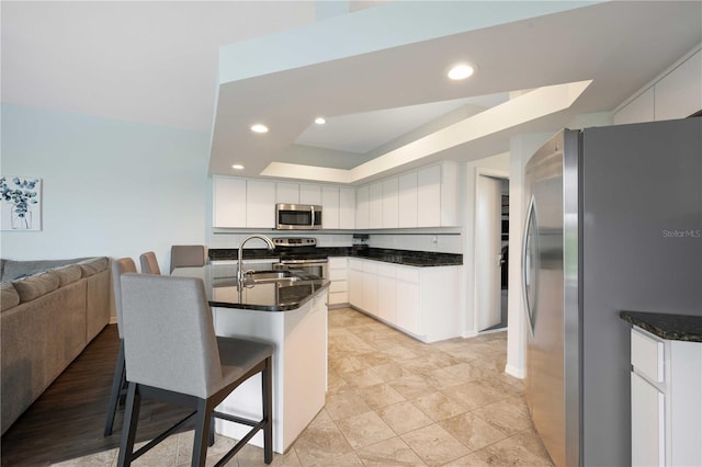 kitchen with white cabinetry, stainless steel appliances, and a sink