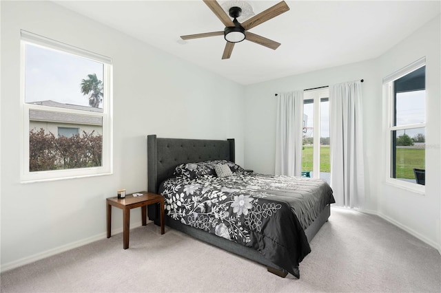 carpeted bedroom with ceiling fan and baseboards