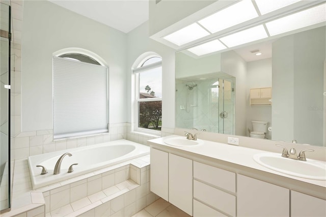 full bathroom featuring a garden tub, a stall shower, a sink, and toilet