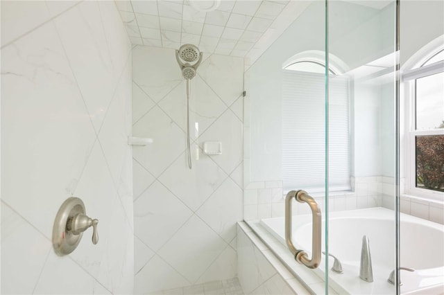 bathroom featuring a bath and tiled shower