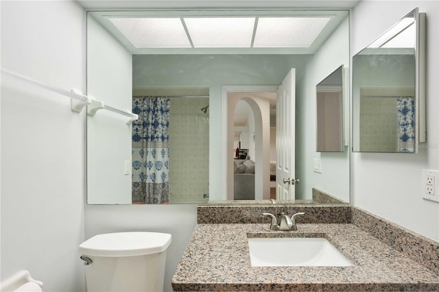 bathroom featuring toilet, a sink, and a shower with shower curtain