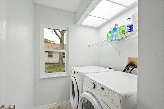 laundry area with laundry area, washer and clothes dryer, and baseboards