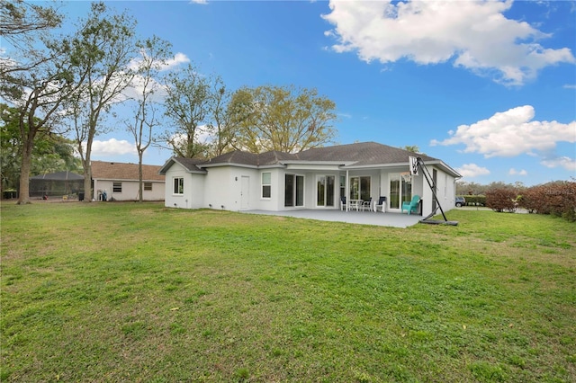 back of house featuring stucco siding, a lawn, and a patio