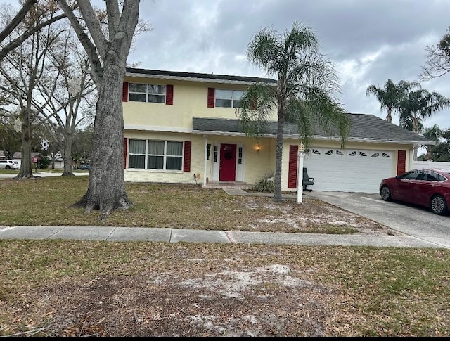 traditional-style home with a garage, a front lawn, concrete driveway, and stucco siding