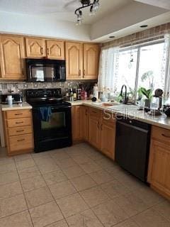 kitchen featuring light tile patterned flooring, a sink, light countertops, decorative backsplash, and black appliances