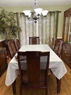 dining room with wood finished floors and an inviting chandelier