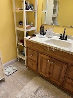 bathroom featuring tile patterned flooring, baseboards, and vanity