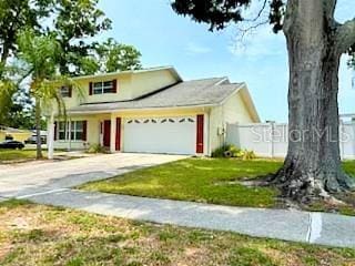 2510 Cypress Bend Dr E, Clearwater, FL 33761 - traditional-style house with a garage, concrete driveway, and a front yard