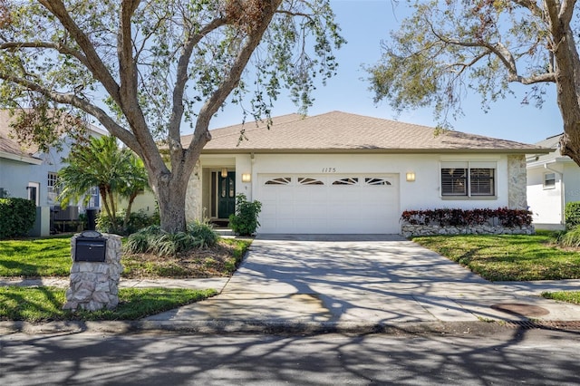 single story home with a garage, concrete driveway, and stucco siding