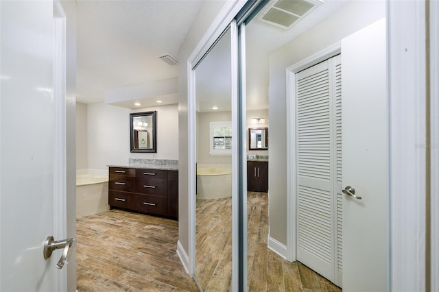 bathroom with visible vents, wood finished floors, and vanity