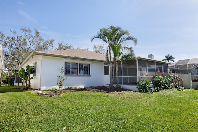 rear view of property featuring a sunroom and a yard