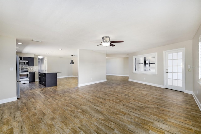 unfurnished living room with ceiling fan, baseboards, wood finished floors, and recessed lighting