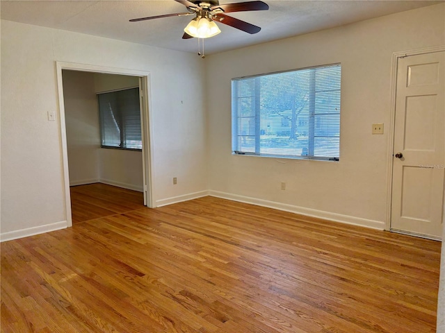 unfurnished room featuring light wood-type flooring, ceiling fan, and baseboards