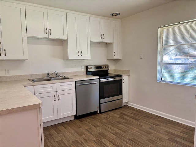 kitchen featuring a sink, stainless steel appliances, light countertops, and white cabinets