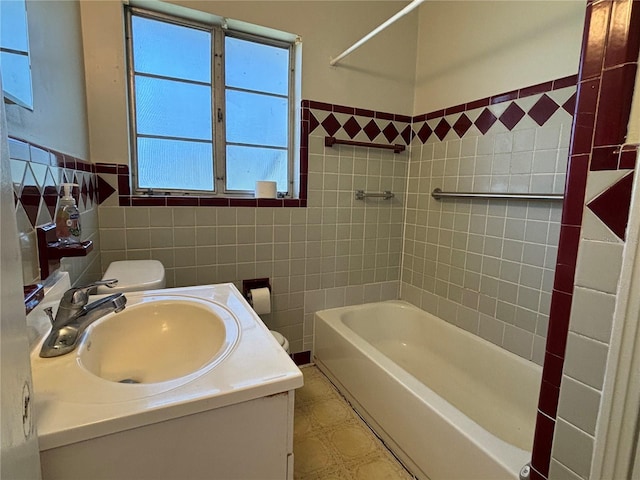 bathroom featuring a wainscoted wall, toilet, tile walls, and vanity