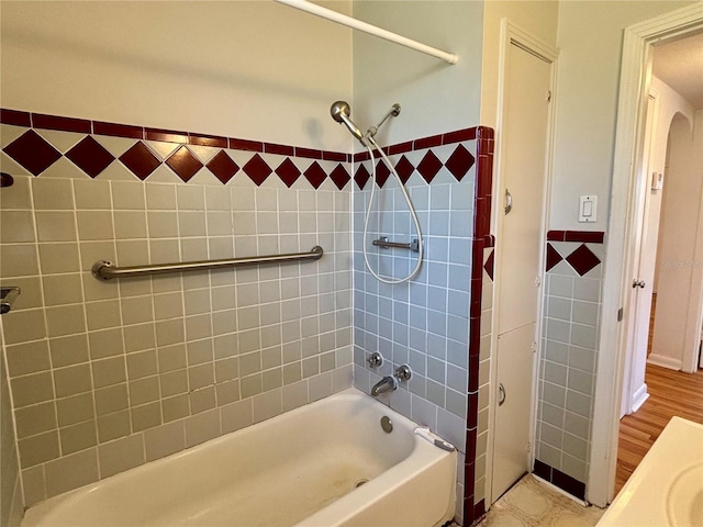 bathroom featuring shower / tub combination and tile walls