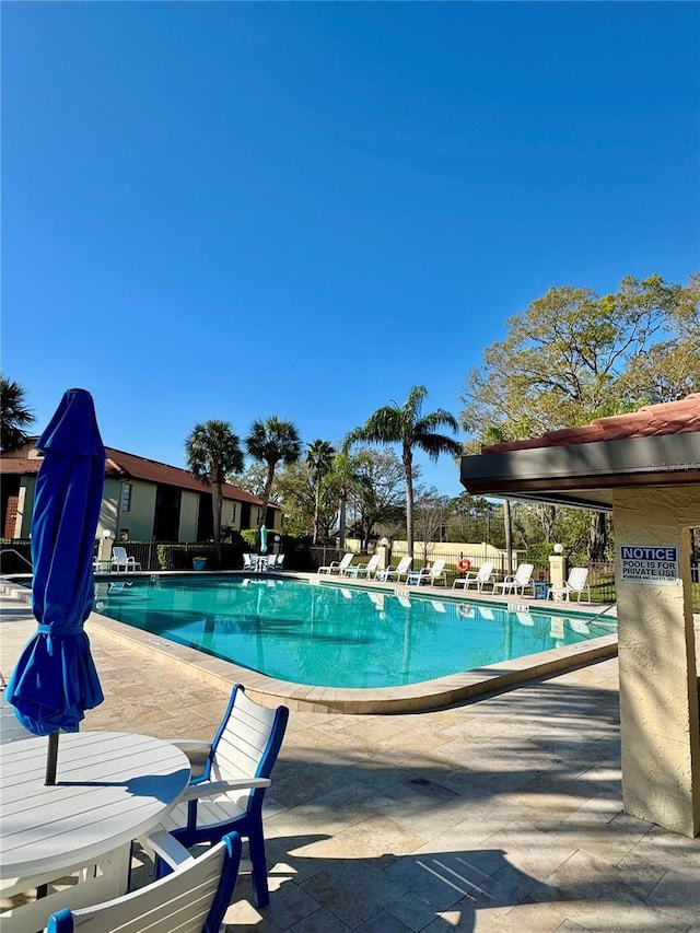 pool with a patio and fence