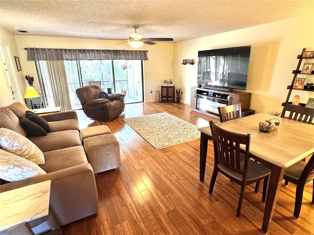 living area featuring ceiling fan, a textured ceiling, and wood finished floors