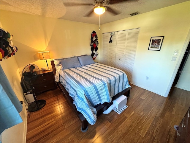 bedroom with dark wood-type flooring, visible vents, ceiling fan, and a textured ceiling