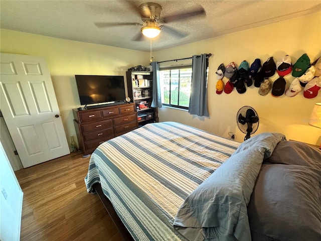 bedroom featuring ceiling fan, a textured ceiling, and wood finished floors