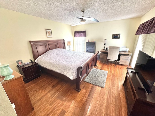 bedroom featuring a textured ceiling, ceiling fan, and light wood-type flooring