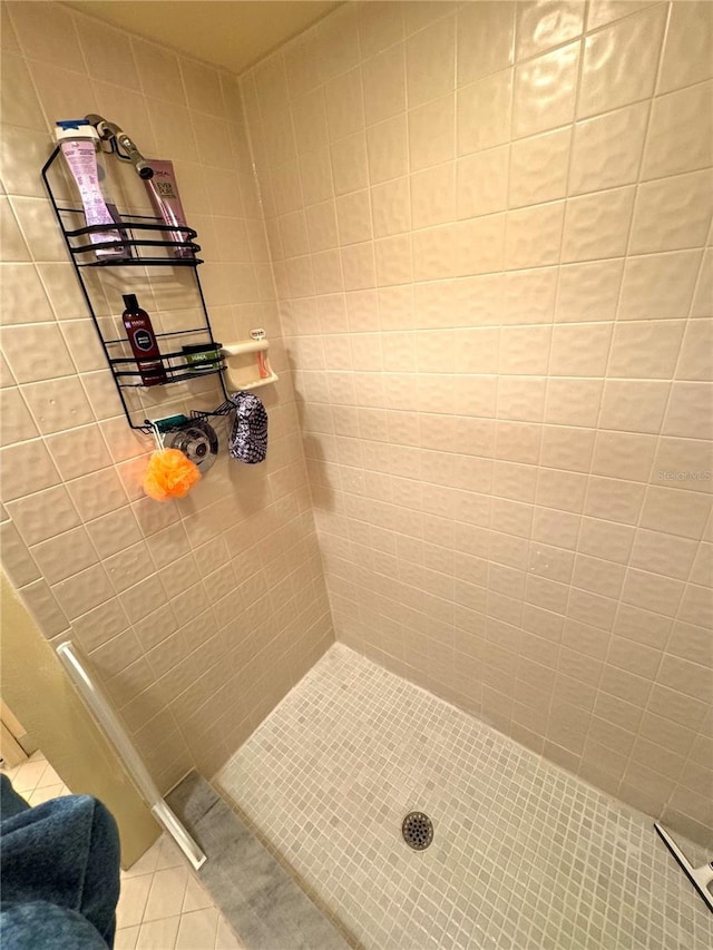 bathroom featuring tile patterned flooring and a tile shower