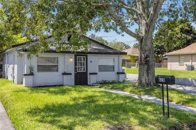 bungalow featuring a chimney, fence, central air condition unit, a front yard, and stucco siding